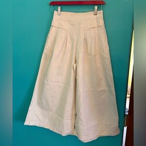 Wide-leg ivory linen palazzo pants or culottes with an elastic waistband.